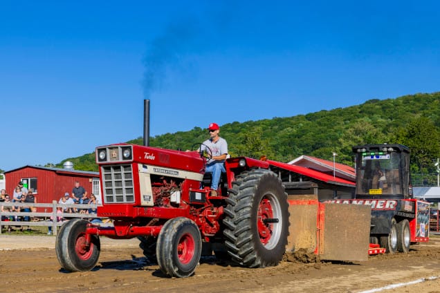 Farmer driving red tractor in an event